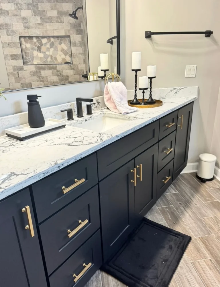 Navy blue bathroom vanity with gold hardware and granite top