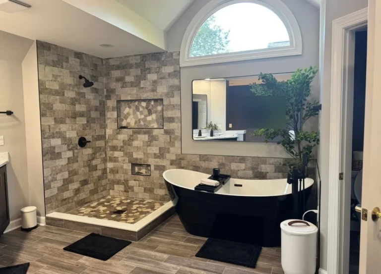 Remodeled master bath with curbless walk-in shower and black freestanding soaking tub