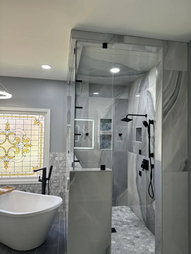 Marble-look tile steam shower with stained-glass window and matte black fixtures