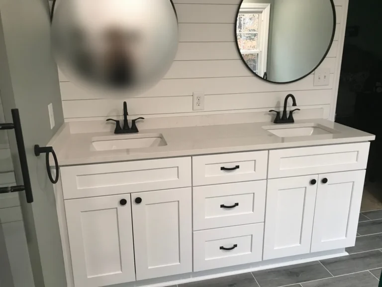 White shaker double vanity with quartz top, shiplap wall and round black mirrors