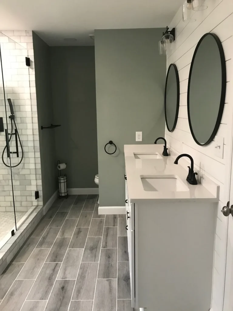 White double vanity with shiplap wall and round black mirrors