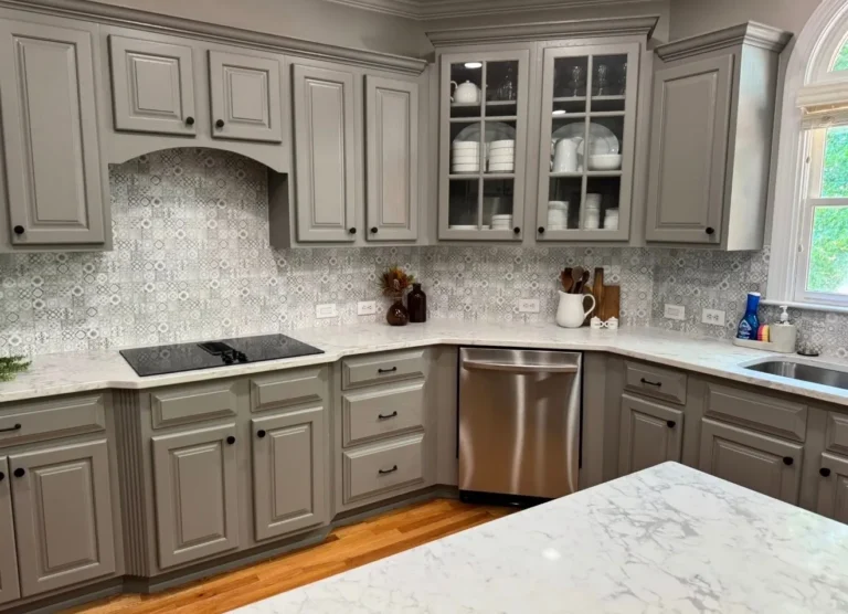 After: gray cabinets, cooktop and dishwasher wall with quartz counters