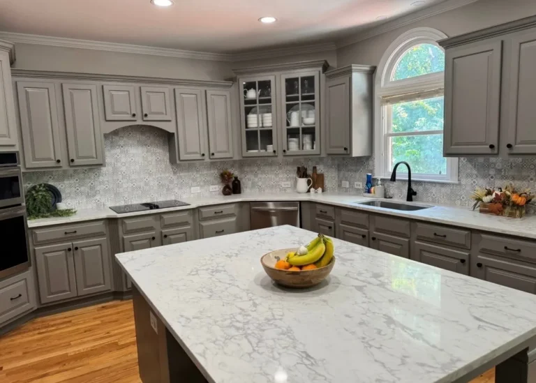 After: gray painted cabinets, quartz counters and island, patterned tile backsplash