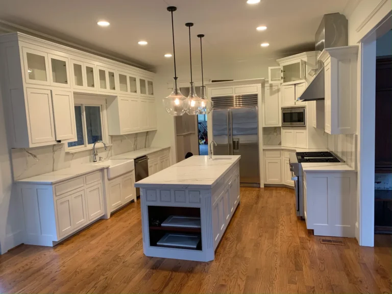After: white painted cabinets and island with pendant lights