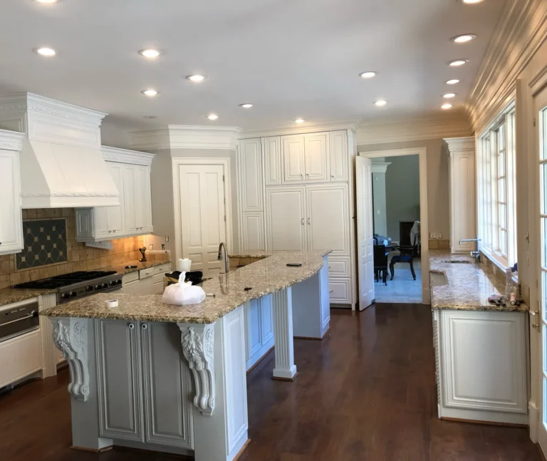 White painted kitchen with granite island and corbels